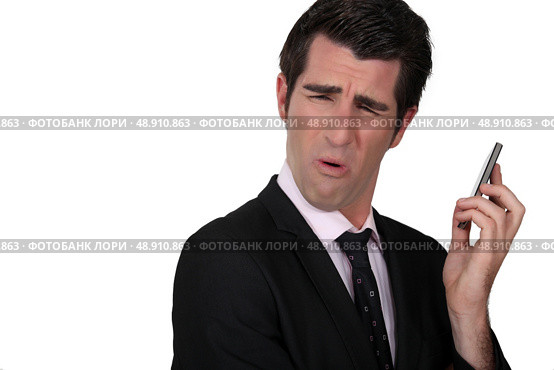 Businessman grimacing at his phone. Стоковое фото, агентство Ingram Publishing / Фотобанк Лори