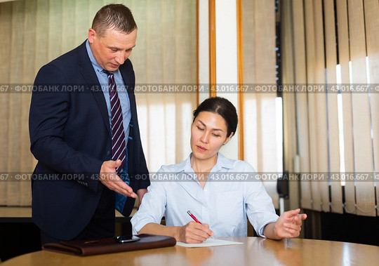 Businessman inviting female business partner to sign papers. Стоковое фото, фотограф Яков Филимонов / Фотобанк Лори