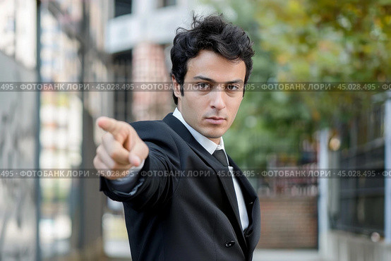 Businessman pointing finger accusingly while standing outdoors. Стоковое AI-изображение, AI-художник Иван Рябоконь / Фотобанк Лори