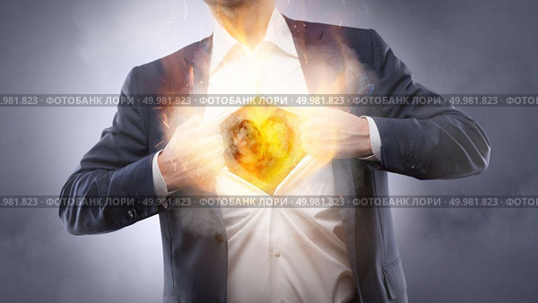 Businessman showing a burning heart onto his chest in suit - crm, service mind business concept. Businessman showing a burning heart. Стоковое фото, агентство Ingram Publishing / Фотобанк Лори