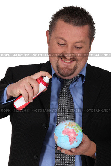Businessman spraying a globe. Стоковое фото, агентство Ingram Publishing / Фотобанк Лори