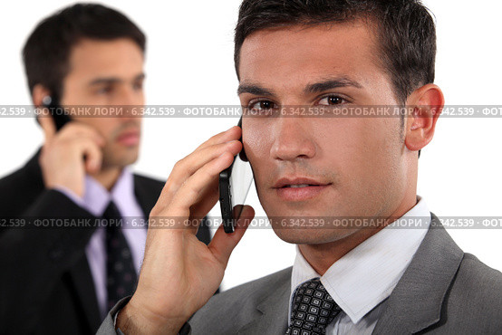 Businessmen talking on their mobile phones. Стоковое фото, фотограф Phovoir Images / Фотобанк Лори