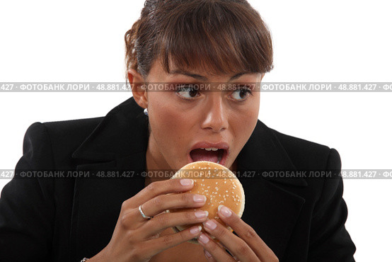 Businesswoman biting a burger. Стоковое фото, агентство Ingram Publishing / Фотобанк Лори