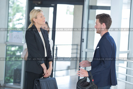 Businesswoman meeting young man holding crash helmet. Стоковое фото, агентство Ingram Publishing / Фотобанк Лори