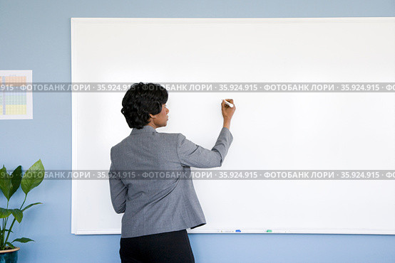 Businesswoman writing on whiteboard. Стоковое фото, фотограф Shannon Fagan / Ingram Publishing / Фотобанк Лори