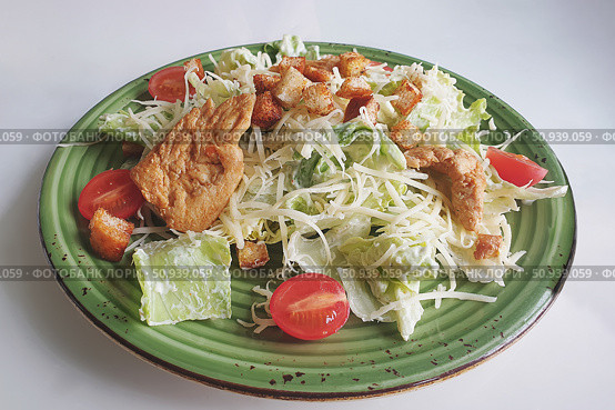 Caesar salad with grilled chicken meat, fresh lettuce, parmesan cheese and fried croutons. Classic North American cuisine. Top view. Стоковое фото, фотограф Оксана Медведева / Фотобанк Лори