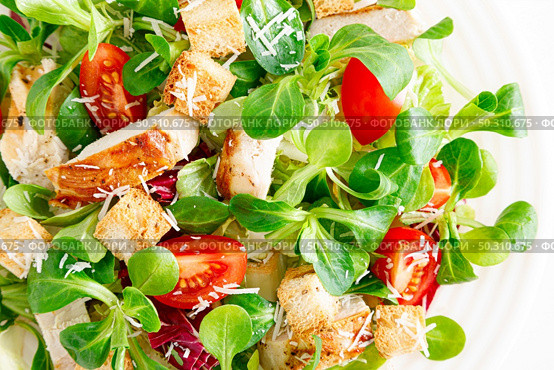 Caesar salad with grilled chicken meat, fresh tomato, croutons, lambs lettuce and parmesan cheese. Healthy lunch. Top view. Стоковое фото, агентство Ingram Publishing / Фотобанк Лори