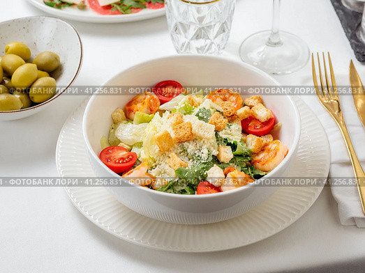Caesar salad with shrimps on restaurant table. Стоковое фото, фотограф Ольга Сергеева / Фотобанк Лори
