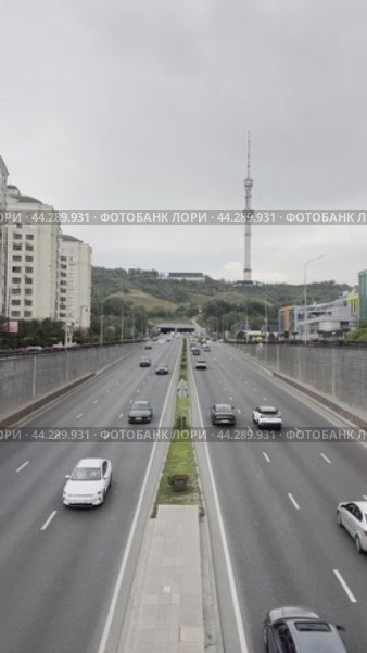 Car traffic on Dostyk Avenue against the backdrop of Mount Kok-Tobe and the city tower. Kazakhstan. Alama-ata. 24.08.2024. Редакционное видео, видеограф Ярославский Максим / Фотобанк Лори