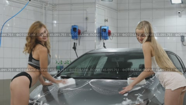 Car Wash. Three Sexy young beautiful girls in a car wash, indoor. Стоковое видео, видеограф Андрей Аркуша / Фотобанк Лори