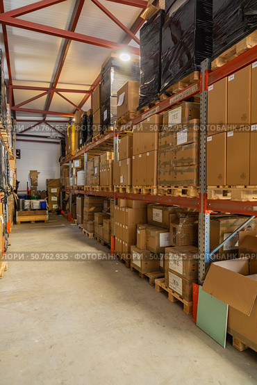 Cardboard boxes sitting on wooden pallets filling warehouse storage space. Стоковое фото, фотограф Юрий Поздников / Фотобанк Лори