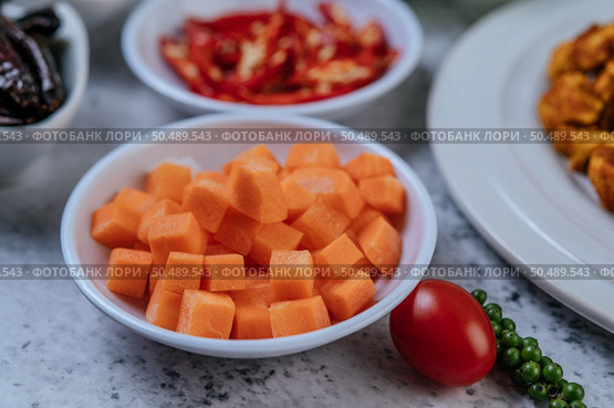 Carrots are diced in a cup with tomatoes and fresh pepper seeds. Стоковое фото, агентство Ingram Publishing / Фотобанк Лори