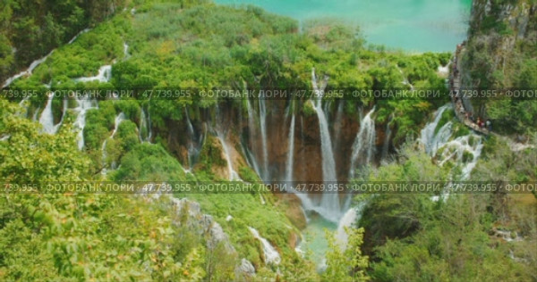 Cascading waterfalls in lush greenery in Plitvice Lakes National Park Croatia. Стоковое видео, видеограф Igor Tichonow / Фотобанк Лори