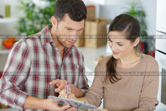 casual couple checking things to do on clipboard. Стоковое фото, агентство Ingram Publishing / Фотобанк Лори
