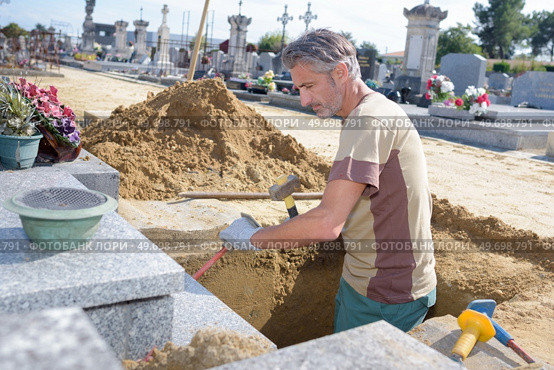 caucasian man digging grave at cemetery. Стоковое фото, агентство Ingram Publishing / Фотобанк Лори