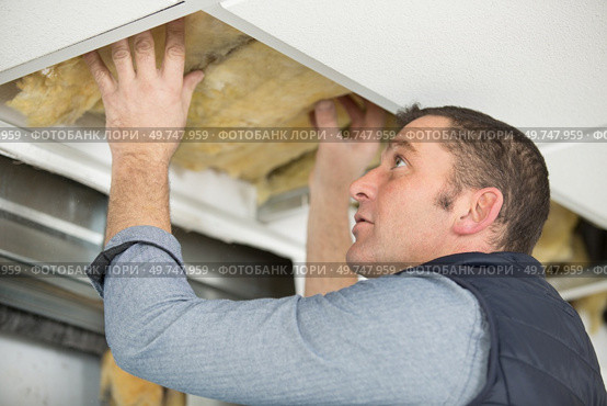 caucasian man fixes ceiling skirting. Стоковое фото, агентство Ingram Publishing / Фотобанк Лори