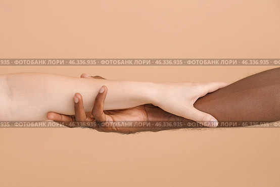 Caucasian woman and African-American man holding hands together on color background. Racism concept. Стоковое фото, фотограф Pixel_shot / Фотобанк Лори