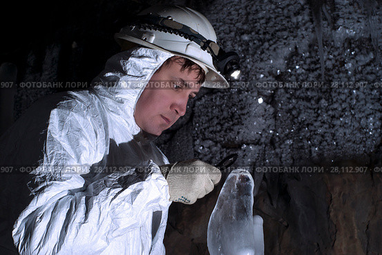 Cave explorer carefully examines the structure of the ice formations through a magnifying glass. Стоковое фото, фотограф Евгений Харитонов / Фотобанк Лори