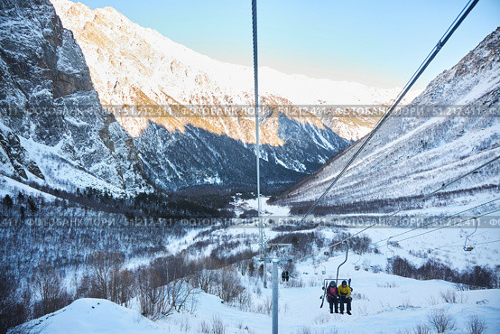 Cei, Russia. - January 06, 2024: A ski lift is visible against the background of a snow-covered mountain. The ski lift is surrounded by trees and snow. Редакционное фото, фотограф Наталия Кирсанова / Фотобанк Лори