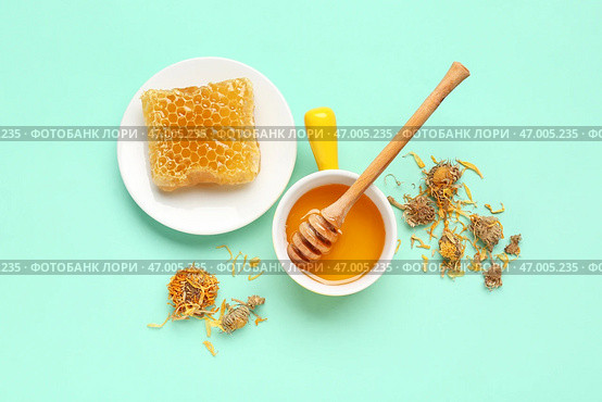 Чаша с вкусным медом, медовым сотом, медовой палочкой и сушеными цветами одуванчика на бирюзовом фоне. Стоковое фото, фотограф Pixel_shot / Фотобанк Лори