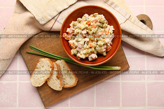 Чаша вкусного салата Оливье и хлеб на фоне розовой плитки. Стоковое фото, фотограф Pixel_shot / Фотобанк Лори