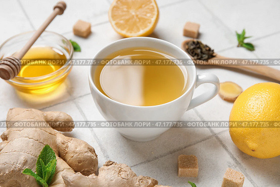 Чашка имбирного чая и миска с медом на фоне белой плитки. Стоковое фото, фотограф Pixel_shot / Фотобанк Лори