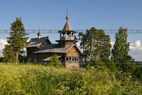 Часовня Рождества Богородицы, деревня Маньга, Республика Карелия, Россия. Большая деревянная православная часовня 18 века постройки в старинной карельской деревне Маньга. Летний пейзаж с храмом на холме среди деревьев. Историческая и архитектурная достопримечательность. (2023 год). Стоковое фото, фотограф Андрей Степанов / Фотобанк Лори