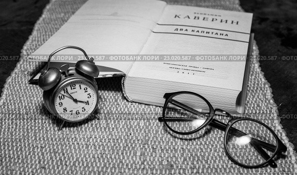 Часы-будильник "Ракета" (СССР), очки и книга (2016 год). Редакционное фото, фотограф Покровский Артур / Фотобанк Лори