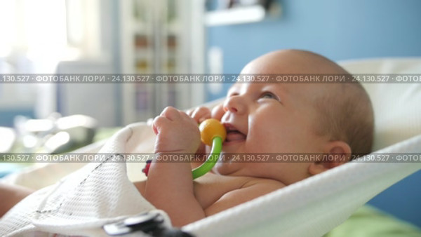 Cheerful little child with a rattle toy in a baby chair. Close up hadheld shot. Стоковое видео, видеограф Павел Котельников / Фотобанк Лори