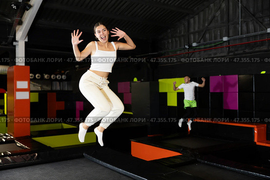 Cheerful young girl jumping in indoor trampoline arena. Стоковое фото, фотограф Яков Филимонов / Фотобанк Лори
