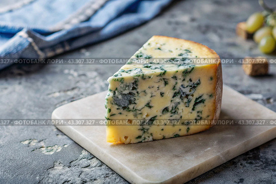 Cheese with mold, a slice of cheese with mold door blue or Roquefort on a cutting board. Delicious food. Стоковое AI-изображение, AI-художник Photojuli / Фотобанк Лори