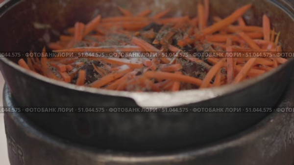 Chef adding spices to carrots and meat in a cauldron. Стоковое видео, видеограф Константин Шишкин / Фотобанк Лори