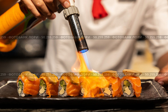 Chef cooking Salmon Foie gras roll, Fusion Japanese Cuisine food, using gas burner torch. Стоковое фото, агентство Ingram Publishing / Фотобанк Лори