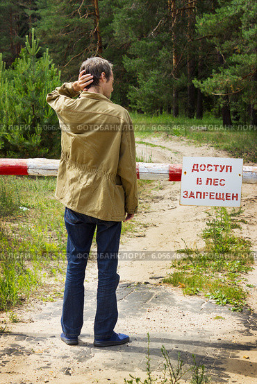 Человек перед плакатом "Доступ в лес запрещен" Стоковое фото, фотограф Александр Романов / Фотобанк Лори