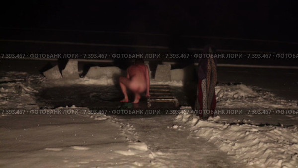 Человек подходит к зимней проруби и нагишом окунается в ледяную воду, ночь. Стоковое видео, видеограф Кекяляйнен Андрей / Фотобанк Лори