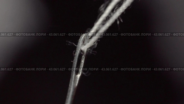Человек вдевает белую нитку в ушко иглы. Man threads a white thread into the eye of a needle. Macro shot. Стоковое видео, видеограф EStarodubov / Фотобанк Лори