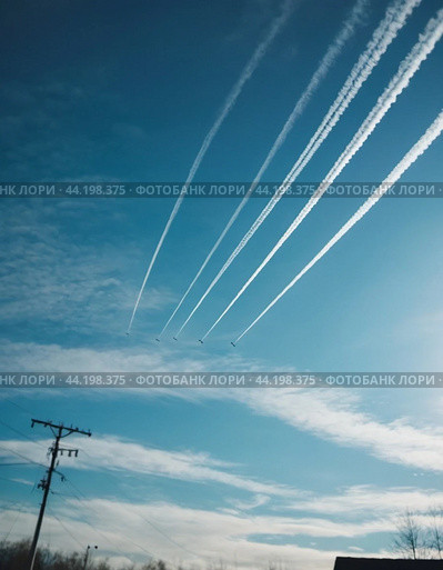 Chemtrail conspiracy theory. Long-lasting condensation trails left in sky by high-flying aircraft are actually chemtrails consisting of chemical or biological agents, sprayed for nefarious purposes. Стоковое AI-изображение, AI-художник Юлия Петровская / Фотобанк Лори