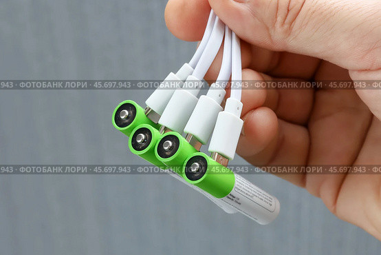 Четыре аккумуляторные батарейки ААА с подключенными штекерами USB проводов зарядки. Стоковое фото, фотограф Vladimir Vikhrov / Фотобанк Лори
