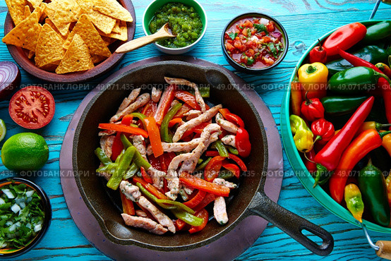 chicken fajitas in a pan with sauces chili and sides Mexican food. Стоковое фото, агентство Ingram Publishing / Фотобанк Лори