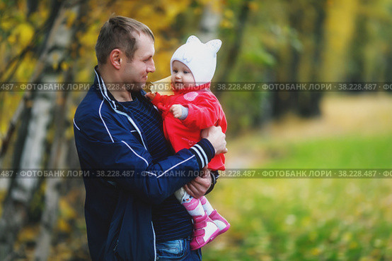 Child in arms of man's father. Autumn day. Pretty, happy, blue-eyed one-year-old girl in red coat and white hat. Charming baby shows emotions close-up. Concept of healthy child and parenting. Стоковое фото, фотограф Aleksandr Golubev / Фотобанк Лори
