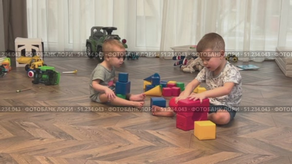 Children joyfully play with colorful blocks, enhancing creativity and cooperation. Стоковое видео, видеограф Olesia Kondrateva / Фотобанк Лори