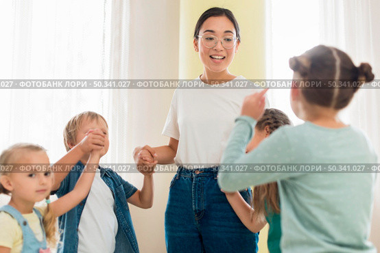 children playing with their kindergarten teacher. Стоковое фото, агентство Ingram Publishing / Фотобанк Лори