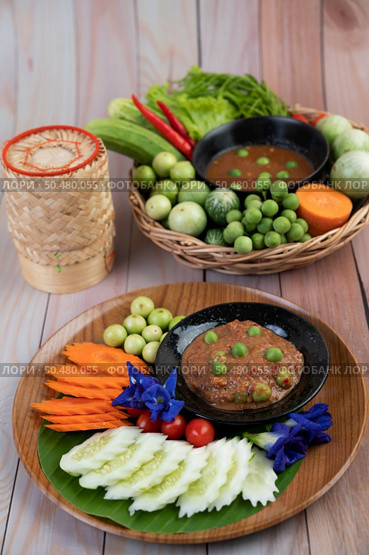 Chili paste paste in a bowl with eggplant, carrots, chili, cucumbers in a basket on wood table. Стоковое фото, агентство Ingram Publishing / Фотобанк Лори