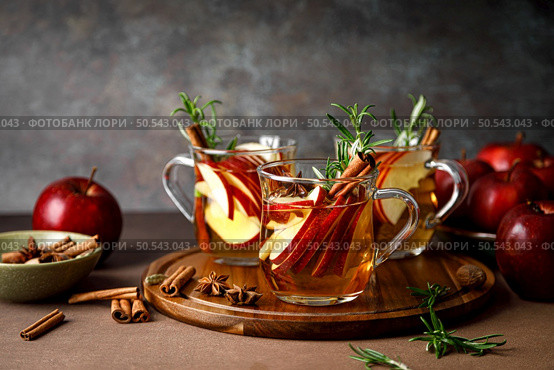 Christmas mulled apple cider with cinnamon, anise and rosemary. Traditional hot drink or beverage, festive Xmas or New Year winter cocktail. Стоковое фото, агентство Ingram Publishing / Фотобанк Лори