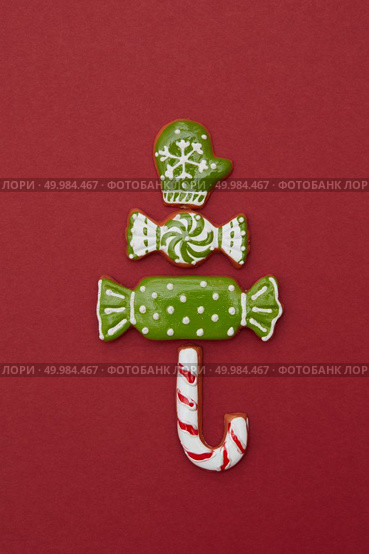 Christmas tree from different gingerbread cookies on a red background. Christmas card. Christmas tree from different gingerbread cookies. Стоковое фото, агентство Ingram Publishing / Фотобанк Лори