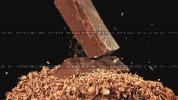 Chunks of chocolate fall into the grated chocolate. Filmed on a high-speed camera at 1000 fps. Стоковое видео, видеограф Артем Шадрин / Фотобанк Лори