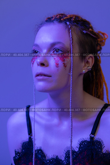 Cinematic night portrait of woman face with shiny make-up with sequins illuminated neon light. Стоковое фото, фотограф А. А. Пирагис / Фотобанк Лори