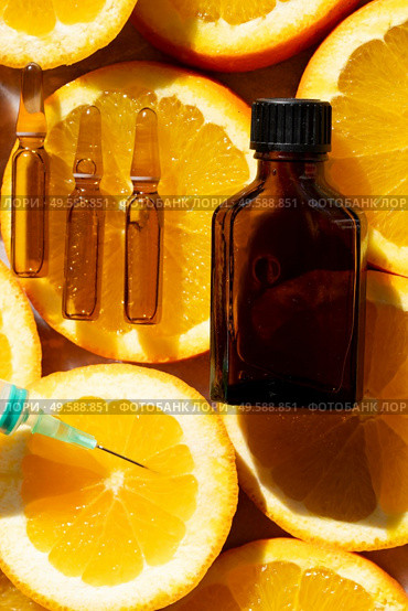 Citrus fruit vitamin c serum oil beauty care in ampullas and bottle close up, anti aging natural cosmetic.. Citrus fruit vitamin c serum oil beauty care. Стоковое фото, агентство Ingram Publishing / Фотобанк Лори