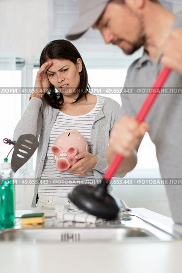 cleaning clogged pipes in the kitchen sink with a plunger. Стоковое фото, агентство Ingram Publishing / Фотобанк Лори