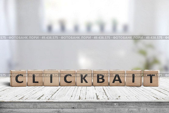 Clickbait word on a wooden sign in a living room with bright daylight. Стоковое фото, агентство Ingram Publishing / Фотобанк Лори